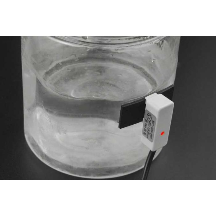 Capacitive sensor for liquid level measurement: non-invasive, accurate, and low-maintenance. Made of metal with a messuring clock face on a water tank in an industrial environment.